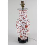 A porcelain baluster table lamp with red foliate decoration on white ground, mounted on hardwood