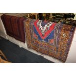 A Turkish wool rug with central geometric design within multi-line borders, in red, blue and yellow,