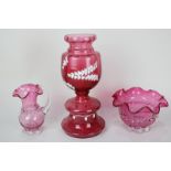 A Mary Gregory style cranberry glass urn with white floral design, 24cm high, together with a