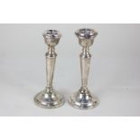 A pair of modern silver candlesticks, baluster shape on circular base, one with drip pan, the