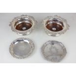 A pair of Walker & Hall silver plated bottle coasters with cast floral borders and turned wooden