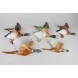 Two graduated Beswick porcelain pheasant wall plaques (model 661), together with three mallard