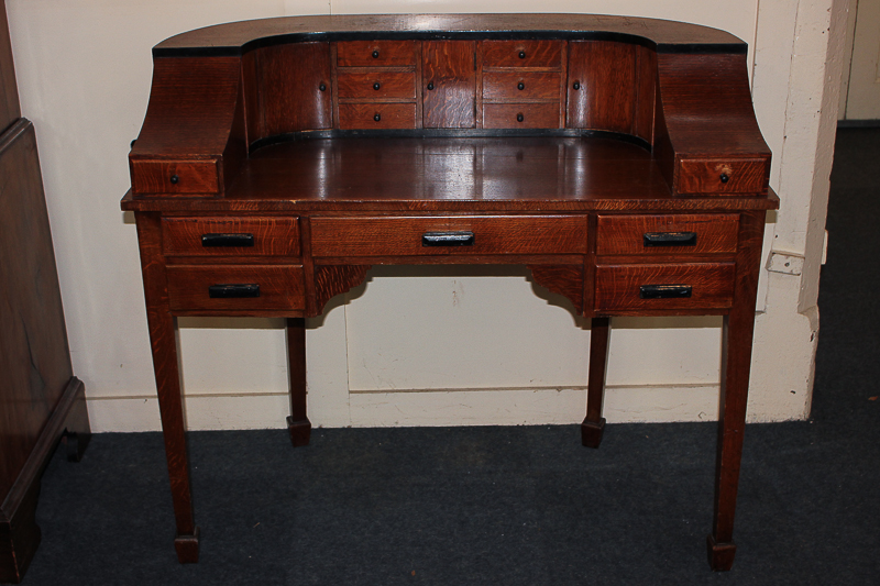 A 20th century oak Carlton House style desk with raised surround of small drawers and pigeon holes