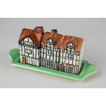 A Beswick pottery cruet set, modelled as a Tudor house, comprising condiment pot, salt and pepper,