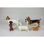 Four Beswick porcelain models of dogs, a begging dachshund (1461) in black and tan, a small corgi (