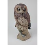 A large Poole Pottery model of an owl, depicting a brown owl on an oak tree stump, 32cm high