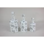 A set of three graduated Limoges porcelain dressing table bottles decorated with flora and fauna (