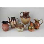 A Doulton Lambeth stoneware brown glazed teapot and large jug, both decorated with countryside