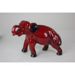 A Royal Doulton flambe model of an elephant with raised trunk, (a/f) 14cm