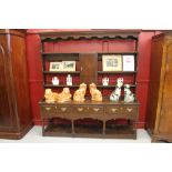 Georgian oak Welsh dresser. The upper section has 4 shelves and a central cupboard door, the lower