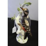 20th cent. European Ceramics: Meissen figure of a great spotted woodpecker perched on a branch,