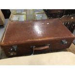 Luggage: Tan leather suitcase fitted with straps. 27ins. x 18ins. x 6ins.