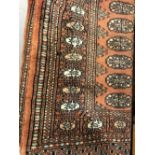 Carpets: Persian red ground Bokhara rug with floral motif medallions, five borders. 56ins. x 47ins.