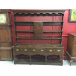 Georgian oak Welsh dresser. The upper section has 4 shelves and a central cupboard door, the lower