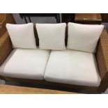 20th cent. Wicker/rattan three seater settee with loose linen cushions. 74ins. x 31ins. x 34ins.