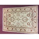 Carpets: Ivory ground machine woven rug with 2 borders and red floral motifs. 66ins. x 50ins.