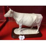 20th cent. Ceramics: Parian model of a cow, on a treen stand. 11ins. x 6½ins. x 4¾ins.