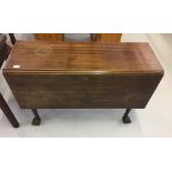 19th cent. Mahogany drop leaf table on turned supports rising off ball and claw feet.
