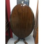 19th cent. Rosewood, oval loo tilt top table, single turned column on four splayed supports.