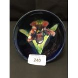 20th cent. Ceramics: Moorcroft footed bowl, orchid on dark blue ground. 4½ins x 4ins.