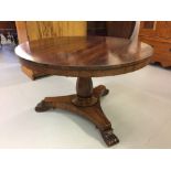 20th cent. Rosewood, circular tilt top dining table on a single pedestal, with carved tripod