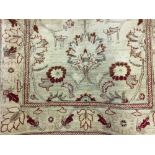 Carpets: Ivory ground machine woven rug with 2 borders and red floral motifs. 66ins. x 50ins.