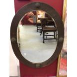 19th cent. Copper framed bevel edged oval mirror. Frame 2¾ins. wide. Hammered decoration with