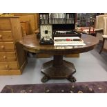 19th cent. Mahogany breakfast tilt top table, raised on an octagonal column and base, on lion paw