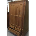 20th cent. Pine double wardrobe with storage beneath, 2 short drawers over 2 long drawers. 42¼ins. x