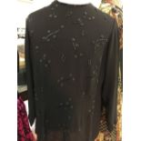 Fashion: Black crepe evening top. Long sleeves, round neck, button back fastening. Heavily trimmed