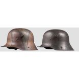 Zwei Stahlhelme M 16 Stahlhelm mit Mimikry-Tarnanstrich in grüngrauer Grundlackierung,