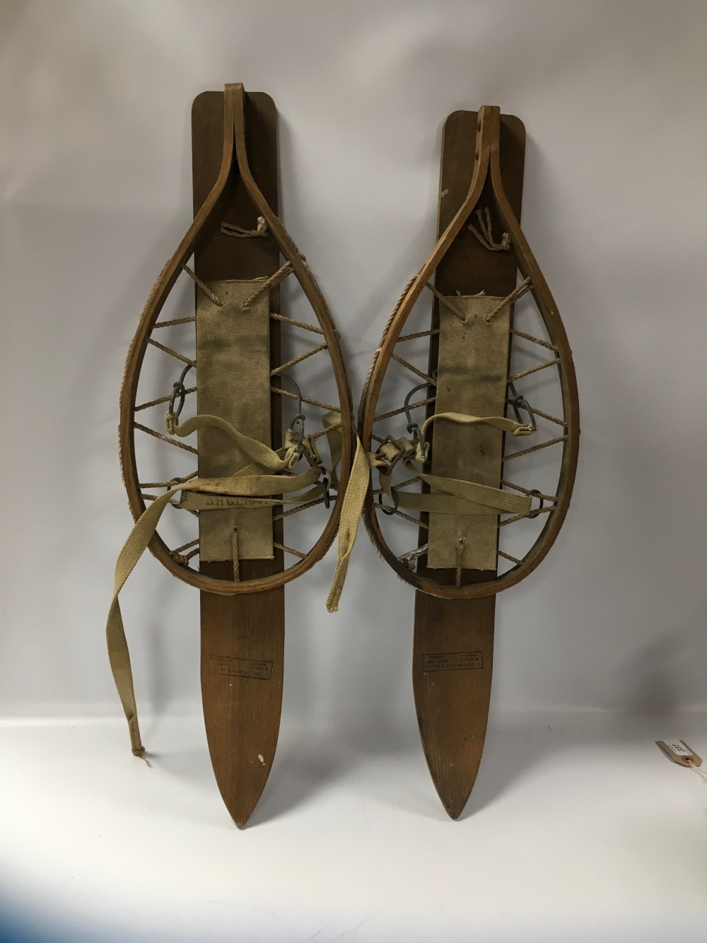 A PAIR OF VINTAGE WOODEN SNOW SHOES WITH COTTON BINDINGS, LENGTH OVERALL 75 CM, STAMPED L.