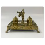 FIVE PIECE BRASS DESK SET ON MATCHING GALLERIED BRASS STAND ON A LION CLAW FOOT WITH MASK DETAILS