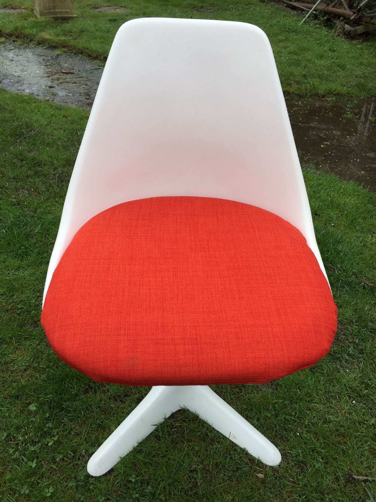 A MAURICE BURKE FOR ARKANA: A RETRO ARKANA STAR CHAIR WITH ORANGE SEAT CUSHION.