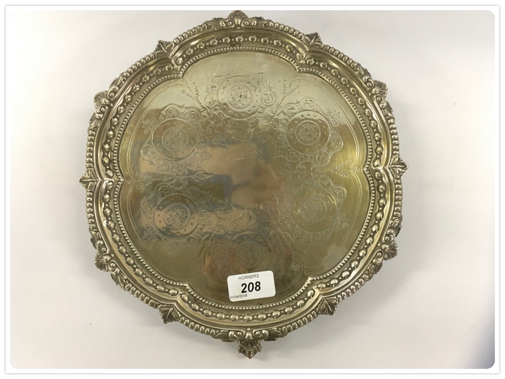 A SOLID SILVER SALVER STANDING ON A BALL AND CLAW FOOT, THE TOP ENGRAVED WITH FRUIT MEDALLIONS,
