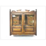 AN EDWARDIAN GLAZED OAK WALL HANGING SMOKERS' CABINET WITH INTERNAL DRAWERS