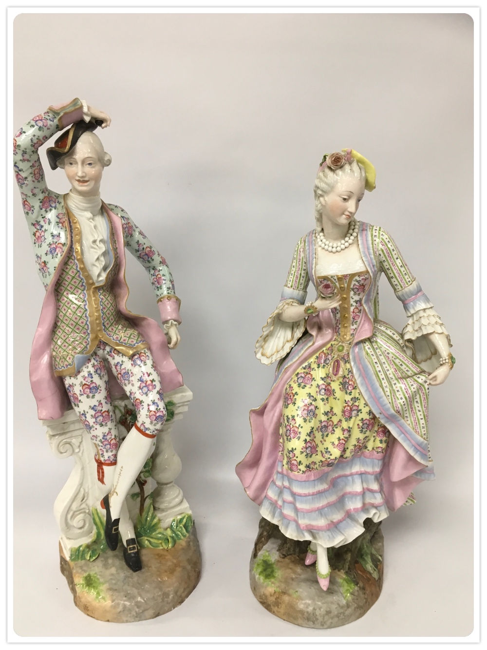 A PAIR OF LARGE C19TH GERMAN HARD PASTE FIGURES OF A MAN AND A WOMAN IN PERIOD DRESS BEARING BLUE