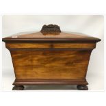 A VICTORIAN SARCOPHAGUS SHAPED MAHOGANY CELLARETTE WITH CARVED FRUIT GARNITURE,