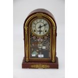 A late 19th/early 20th century American-type mantel clock, the arched simulated rosewood case