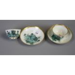 A pair of 18th century European porcelain tea bowls and saucers decorated with landscapes in green