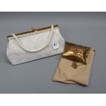 A white beaded clutch bag together with a metal small evening bag