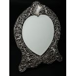 A Victorian silver table mirror by William Comyns, the cartouche-shaped frame profusely decorated