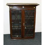 An Edwardian oak, lozenge strung bookcase, the moulded cornice over a pair of astragal glazed