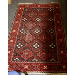 A red ground 20th century Turkoman rug, with tile scheme and border, 90 x 165cm