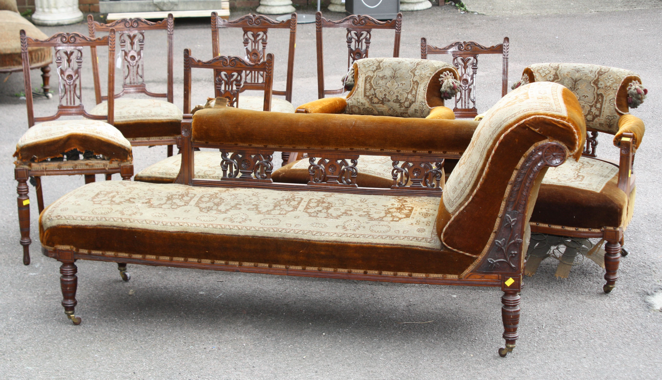 A Victorian walnut nine piece salon suite with carved decoration, comprising nail back chaise