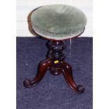 A Victorian carved walnut revolving piano stool with decorative shaped supports
