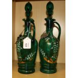 A pair of Victorian green glass spirit decanters and stoppers, each with wavy rim and elongated loop