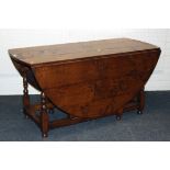 A 18th century style oak gateleg dining table, of pegged construction, the plank top and twin