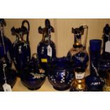 A collection of largely late 19th century Continental blue glass and enamel decorated jugs and