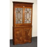 A 19th century mahogany floor standing corner cupboard, the moulded cornice over a pair of